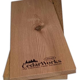 Smooth cedar wood sample with natural grain, featuring Cedar Works branding and tagline "The Ultimate Taste Sensation". Ideal for custom woodworking, furniture, or decking projects.