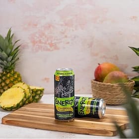 Vegan energy drinks on a wooden cutting board with pineapples, apples, and grapefruit in a fresh, vibrant kitchen setting. Perfect for healthy lifestyle and natural energy boost.