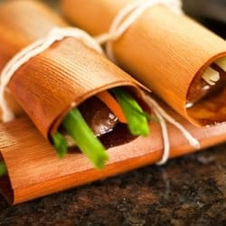 Natural cedar wood sushi roll holder with fresh green ingredients for eco-friendly dining.
