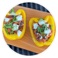 capsicum peppers stuffed with cheese on a cedar grilling plank
